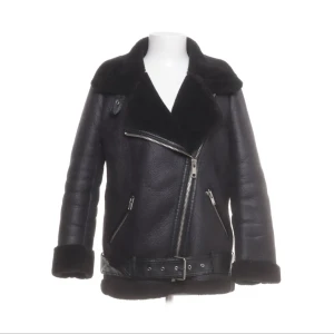 Svart teddyjacka från Zara, S - Svart teddyjacka från Zara med bred krage, synliga dragkedjor och bälte nedtill. Jackan har mjukt foder, uppvikta muddar och två fickor med dragkedja. Snygg oversized look och perfekt för kalla dagar samt kan man ha den under vintern. Stängs med sned dragkedja framtill. Jackan har jag användt 2 gånger och är köpt för 1200kr. Säljer den för 800 ( pris kan diskuteras)💓💓💓