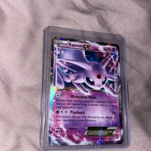 Espeon EX - Cool och glittrig Pokémon-samlarbok med Espeon EX! Perfekt för dig som älskar Pokémon och vill ha en unik kortbok i din samling. Kortet har snygg design och är skyddat i plastfodral. Ett måste för alla unga Pokémon-fans!