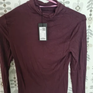 Vinröd polotröja från lager 157 - Snygg vinröd polotröja i mjuk bomull. Tröjan har lång ärm och en klassisk polokrage som ger en stilren look. Perfekt att matcha med jeans eller kjol för en trendig vibe.