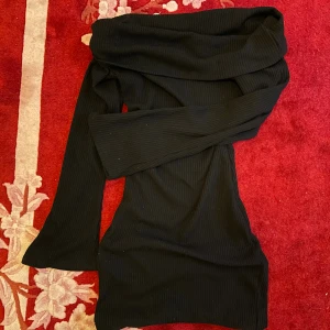 svart ribbad offshoulder klänning - säljer en svart ribbad klänning med offshoulder-design och långa utsvängda ärmar!! figurnära klänning som sitter snyggt! 