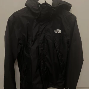 Svart vindjacka från The North Face - Säljer en svart Antora Jacket från The North Face med huva och dragkedja. Mycket bra skick. Nypris 1200 kr.