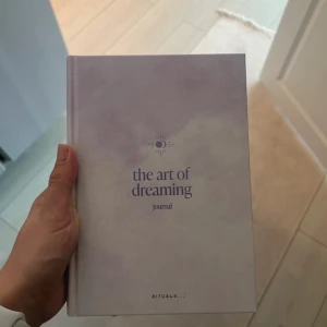 the art of dreaming journal Ritauls  - En stilren och inspirerande journal med mjuka lila toner, perfekt för dig som vill utforska dina drömmar och tankar. Passar dig som gillar att skriva, reflektera och utvecklas. Skapa din egen berättelse och fånga dina idéer på ett kreativt sätt!