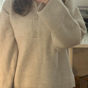 Beige stickad tröja med krage & knappar - Mysig beige stickad tröja från Gina Tricot  med krage och knappar framtill.  