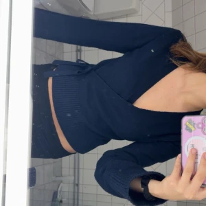 Mörkblå omlottkofta med knyt - Säljer en mörkblå omlottkofta med knyt från gina i sidan och djup v-ringning. Tröjan är ribbad i midjan och har långa inte så tighta armar. Älskar materialet och den är i princip helt ny💓