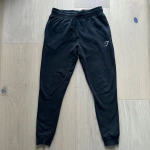 Svarta Gymshark byxor - Säljer de här sköna svarta byxor från Gymshark med broderad logga. Byxorna är i storlek S