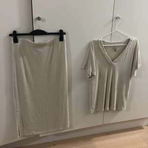 Beige ribbad sett med slits - Säljer ett beige sett med ribbad struktur och en liten slits nedtill på sidan. Kjolen har en enkel, rak passform och är gjord i ett mjukt material som känns skönt mot huden. Perfekt för en enkel chill look. 200 separata 