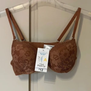 Brun BH - Säljer en brun BH från Primark med push-up effekt och justerbara axelband. 