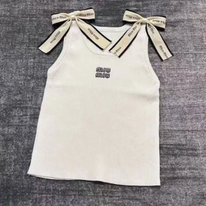 Miu Miu ribbad linnetopp med rosetter - Säljer två ribbade linnetoppar från Miu Miu, en i vit och en i svart. Båda har breda axelband med dekorativa rosetter och Miu Miu-logga framtill. Topparna är ärmlösa och har en clean, croppad passform som är perfekt för att lyfta din look.