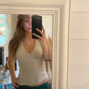 Halternecktopp i guld  - Öppen rygg. Guldig med detaljer.