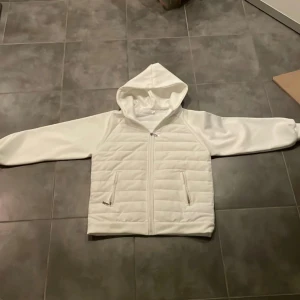 Vit cardiganjacka - Säljer denna vita cardigan jackan i stl S. Jackan är i väldigt bra skick förutom att dragkedjan är lite trög och baksidan är lite smutsig men jag tvättar den innan jag fraktar. Hör av er vid frågor, kom inte med 30% prisförslag för har redan sänkt den en del!