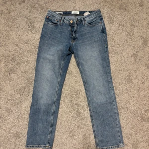 Blå jeans från Jack & Jones, 29/30 - Snygga blå jeans från Jack & Jones i klassisk modell med raka ben och fem fickor. Jeansen har normal passform och är tillverkade i slitstarkt bomullstyg. Perfekta för dig som gillar en enkel och tidlös stil.