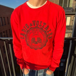 Röd sweatshirt från Zadig & Voltaire - Riktigt snygg röd sweatshirt från Zadig & Voltaire med stort svart tryck framtill. Modellen är 188 och den passar men lite kort.