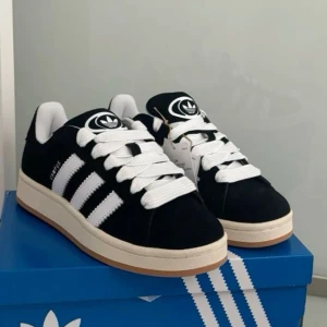 Adidas Campus sneakers svart/vit - Säljer ett par klassiska Adidas Campus sneakers i svart mocka med vita detaljer, säger för att dom knappt har kommit till användning, använt mellan 2-3 ggr. OBS: betalning sker genom vanlig Swish och ej genom appen då jag är ny här och inte förstår hur man postar genom appen 