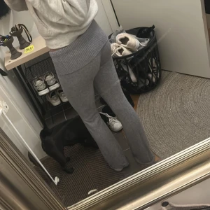 Grå stickade byxor från Gina Tricot - Mysiga grå stickade byxor från Gina Tricot med bred ribbad midja och raka ben. Perfekta för chill dagar och har en skön loose fit. Materialet är mjukt och stretchigt vilket gör dem superbekväma att ha på sig.