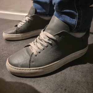 Gråa Axel Arigatos - Säljer nu mera mina Axel Arigatos som går för 1700 ny pris. Använt dom i 2 månader. Storlek 39. Säljer för dom är för små. Hör av er om ni har funderingar. Priset ej hugget I sten