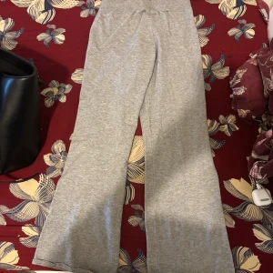 Grå  styckad mjukisbyxor från Gina Tricot - Ops ‼️har ett litet hål på framsidan men annars jätte fina Grå stickad mjukisbyxor från Gina Tricot med bred ribbad midja och snörning. Byxorna har en loose fit och raka, vida ben. Tillverkade i mjukt bomullsmaterial som är skönt mot huden. Perfekta för chill dagar eller när du vill vara bekväm. Är bra för barn eftersom den är ifrån Young Gina 