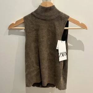 Brun stickad med polokrage från Zara - Snygg brun stickat linne från Zara med hög polokrage och ärmlös design. Mjuk och skön kvalitet som ger en och helt oanvänd med lappen kvar. Säljer då den inte passar mig. 