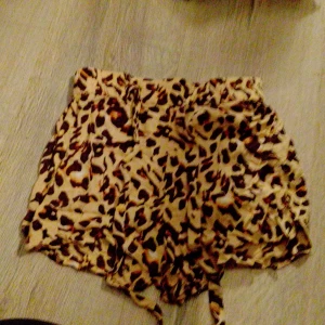 Leopardmönstrade shorts från Pieces - Säljer ett par snygga shorts från Pieces med leopardmönster i beige och bruna toner. De har hög midja och snörning i midjan för extra passform. Perfekta för sommaren när du vill sticka ut lite extra.