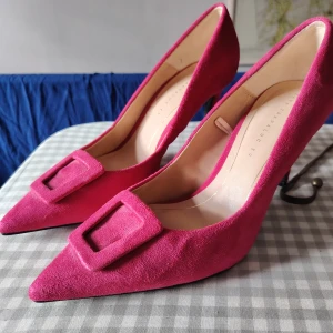 ZARA TRAFALUC - Pumps i rosa mocha - Helt nya [39] - Helt nya rosa pumps från designer Zara Trafaluc i mocka med spetsig tå och dekorativt spänne framtill. Skorna har hög klack och en elegant form som verkligen sticker ut. Perfekta för dig som vill ha ett statement-piece i garderoben. 