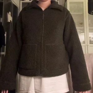 Mörkgrön teddyjacka med dragkedja - OBS! Om ni vill köpa lägger jag ut på nytt för fri frakt! Mysig mörkgrön teddyjacka med hög krage och hel dragkedja framtill. Jackan har två stora fickor och är tillverkad i fluffigt teddy-material. Passformen är loose och ärmarna är långa, perfekt för kyliga dagar. Kontakta mig för fler bilder eller om ni vill ha tydligare bild på färgen🥰Storlek M men passar även S 