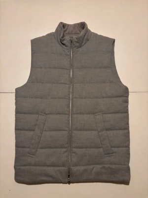 Grå flanell väst från Dressmann - Säljer en stilren grå väst från Dressmann i storlek M. Västen är gjord i flanell, har två fickor fram och hel dragkedja. Insidan av kragen är i mjuk manchester med diskreta ränder. Perfekt att slänga över en hoodie eller tröja när det är kyligt ute. Skriv om du skulle ha någon fråga!