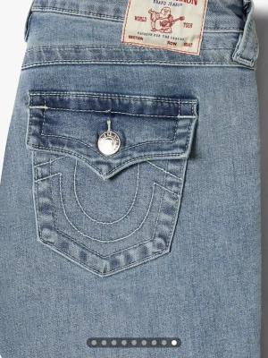 Bootcut jeans från True Religion - Säljer ett par ljusblå bootcut jeans från True Religion med klassiska fickor och silverfärgade knappar bak. Jeansen är helt nya, använda fåtal gånger. Lågmidjade