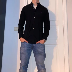 Svart skjorta från Ralph Lauren  - Svart skjorta från Ralph Lauren i storlek M. Fint skick till ett bra pris. Nypris: 1995kr. Mitt pris: 549. Vid frågor eller funderingar, tveka inte att höra av dig.