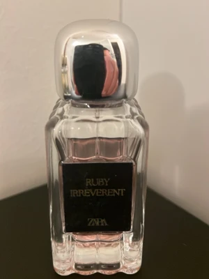 Ruby Irreverent parfym från ZAPA - Upptäck Ruby Irreverent från ZAPA – en parfym med modern design och rosa tonad vätska. Perfekt för dig som vill sticka ut och addera en cool touch till din stil.
