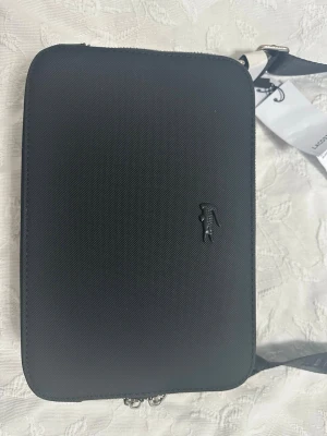 Svart axelväska från Lacoste - Snygg svart axelväska från Lacoste 