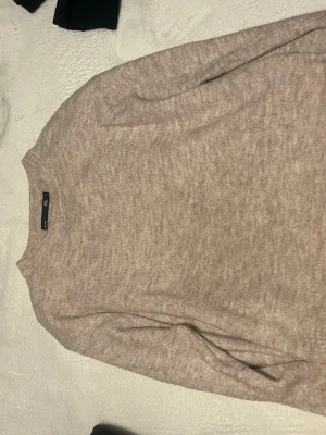 Beige stickad tröja från lager - Mysig beige stickad tröja från lager med rund halsringning och långa ärmar. Perfekt för lager på lager och enkel att matcha med jeans eller kjol. Tröjan har en mjuk känsla och klassisk passform.