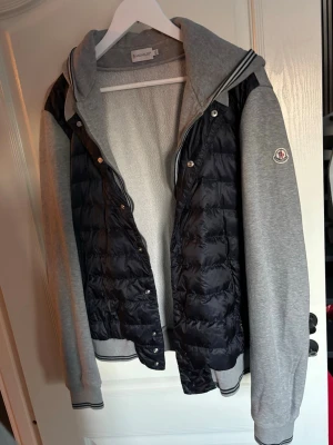 Moncler cardigan - Säljer denna feta cardigan från Moncler! Skick 8/10 - inga defekter. Nypris 7999kr, mitt pris endast 2099kr. Storlek barn XXL, passar M/L herr. Hör av er vid funderingar!
