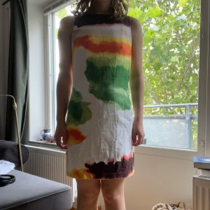 Färgglad kort klänning från Desigual - Säljer en superfin ärmlös kort klänning från Desigual med färgstarka penseldrag i grönt, orange, gult, brunt och vitt. Klänningen har rund halsringning och dragkedja bak. Perfekt för dig som gillar unika och färgglada plagg!