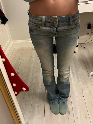 Lågmidjade bootcut jeans ljusblå - Säljer ett par lågmidjade ljusblå jeans med bootcut passform. Jeansen har dubbla knappar i midjan🩵🩵 