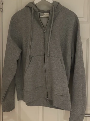 Helt ny Zara heavyweight hoodie  - En Grå heavyweight hoodie med dragkedja från Zara Origins. Säljs pga fel storlek Snygg och simpel hoodie som passar till allt. Kraftigt och kompakt material.  • Storlek: M  • Färg: Grå • Modell: Heavyweight zip hoodie • Skick: Helt ny  