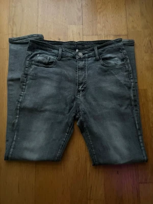 Mörkgrå jeans - Snygga mörkgrå jeans med klassisk femficksdesign och smal passform. Jeansen har en lätt tvättad look och är tillverkade i mjukt jeansmaterial med dragkedja och knapp framtill. Perfekta för dig som gillar stilrena och moderna jeans. Skriv för mer bilder eller frågor