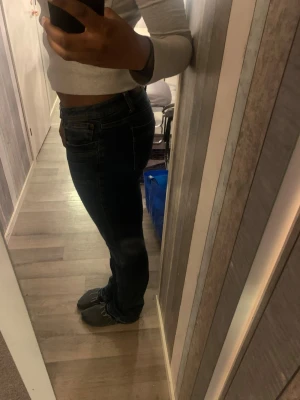 bootcut jeans - Säljer ett par mörkblå jeans med bootcut-snitt och fransad kant längst ner. Jeansen har klassisk femficksdesign och är midwaist. Materialet är jeans och passformen är normal. Perfekt för dig som gillar en chill och stilren look. 29/36