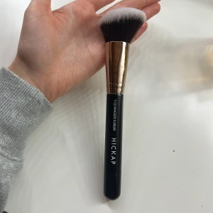 Hickap 112 Angled Kabuki sminkborste - Säljer en Hickap 112 Angled Kabuki sminkborste med svart handtag och metallfäste i silver. 