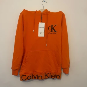 Calvin Klein hoodie  - Helt ny Calvin Klein hoodie i snygg orange färg, fortfarande med prislapp! Storlek M. Säljes för 159kr