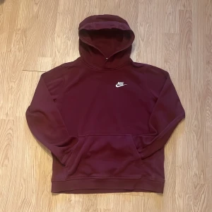 Nike Hoodie Vinröd S - Säljer en vinröd Streetwear baggy hoodie från Nike i storlek S. Tröjan har klassisk huva, magficka och broderad vit Nike-logga på bröstet. Perfekt för chill dagar eller när du vill ha en street blandat med sportig look. Mjuk insida och långärmad boxy modell. Riktigt fin kvalitet utan större tecken på användning!👑