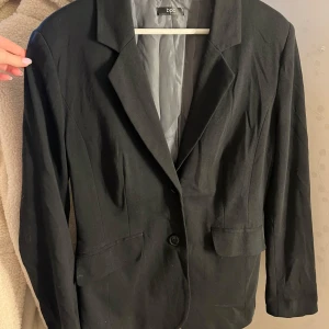  Figursydd kavaj  - Vanlig svart figursydd kavaj många år gammal men ändå Fräch storlek 42 men passar även 40! 