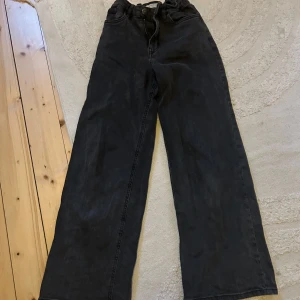 Svarta wide jeans från Lindex - Säljer ett par svarta jeans från Lindex i storlek 146. Byxorna har en loose och wide passform med hög midja och raka ben. Klassisk femficksmodell och tillverkade i mjukt bomullstyg. Perfekta för en avslappnad och trendig look. Använda några få gånger men väldigt bra skick, inga defekter. Priset kan diskuteras 🥰
