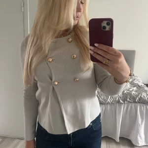 Ljusgrå  kofta med guldknappar - Stilren kofta 
