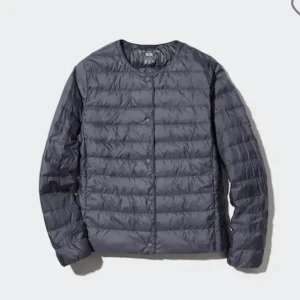 Mörkgrå dunjacka från Uniqlo - Säljer en stilren mörkgrå dunjacka från Uniqlo med rund hals och knappar framtill. Jackan är lätt, quiltad och har en clean look utan krage. Perfekt att slänga på sig när det är kyligt ute. Bilden är lånad men min är bara använd en gång och ser som ny ut. Skriv om fler bilder önskas!!