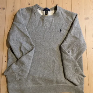  Sweatshirt grå  Polo Ralph Lauren - Pris kan diskuteras, skriv för mer bilder!Klassisk grå sweatshirt från Polo Ralph Lauren med rund halsringning och broderad logga på bröstet. Tröjan har långa ärmar och ribbade muddar vid ärmslut och nederkant. Perfekt för en chill och stilren look.