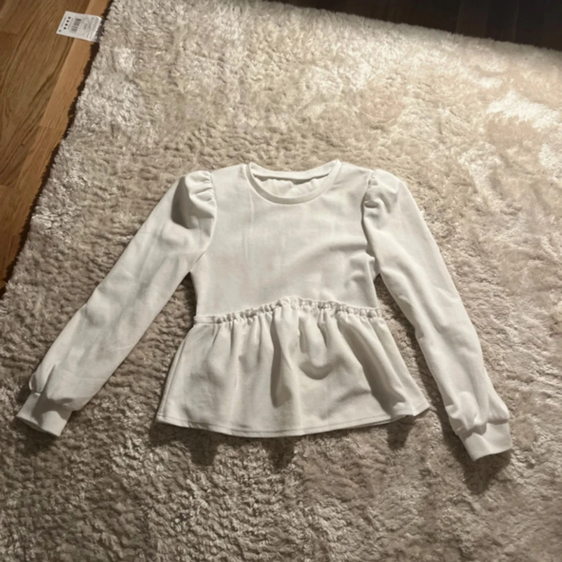 Vit blus med puffärm och volang