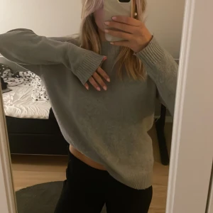 Grå stickad oversized tröja - Mysig grå stickad tröja med oversized passform och långa ärmar. Tröjan har breda ribbade muddar vid ärmslut och halsringning. Perfekt för lager-på-lager och chill dagar.