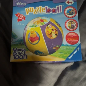 Winnie the Pooh Puzzleball - Bygg en 3D-pusselboll med motiv från Winnie the Pooh! Perfekt för dig som gillar utmaningar och vill ha något kul att visa upp i rummet. Innehåller 24 bitar och passar både yngre och äldre fans av Nalle Puh och hans vänner.