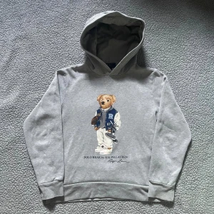 Grå hoodie Polo Bear Ralph Lauren - Säljer en grå hoodie från Polo Ralph Lauren med ikoniska Polo Bear trycket👕 väldigt bra skick✅ skickar snabbt efter att du har beställt📦