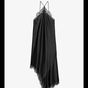 Svart asymmetrisk satinklänning med spets - Supersnygg svart klänning i satin med asymmetrisk fåll och tunna axelband + har spetsdetaljer. Använd 1 gång. Nypris 700kr