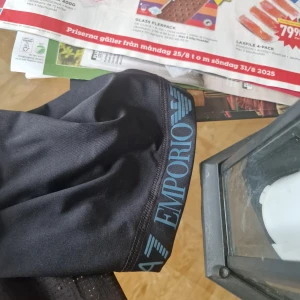 Svart EA7 Emporio Armani t-shirt - Snygg svart t-shirt från EA7 Emporio Armani med logga på bröstet och tryck på ärmen. T-shirten har korta ärmar och är gjord i ett lätt, sportigt material som andas. Perfekt för dig som gillar stilrena och exklusiva plagg med sportig vibe.pris kan diskuterasvid snabbaffär o jag köpt från jd sport hemsida ny pris 850 kr de är en tränings t shirt i storlek L jag kan mötas i sthlm